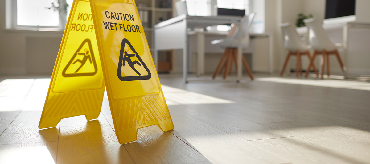 A wet floor sign in the middle of an office interior.