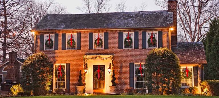 A brick house with holiday lights and decorations