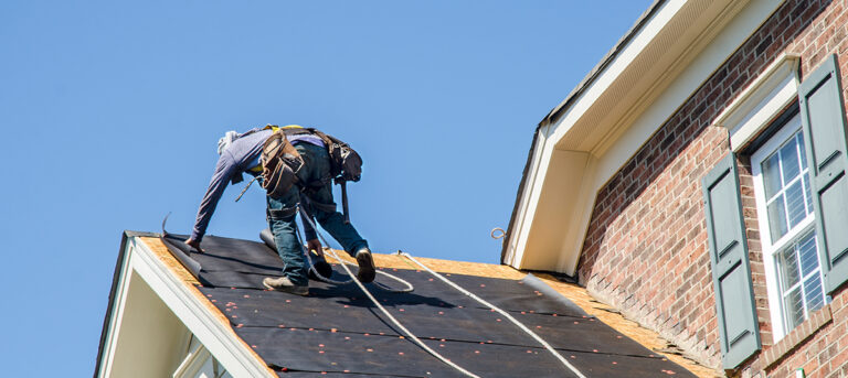 a contractor working on a roof that has Roofing Contractors Insurance