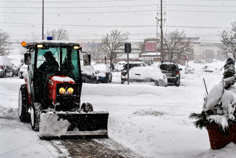 Snowplow clearing snow as part of a snow removal program to reduce winter hazards and prevent slip, trip, and fall incidents